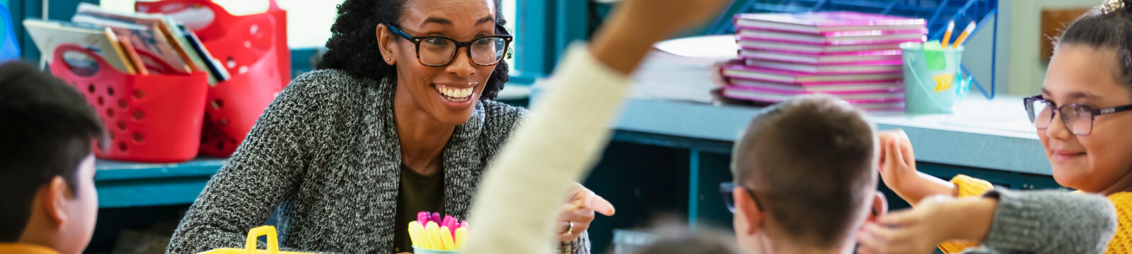 teacher smiling at a group of students